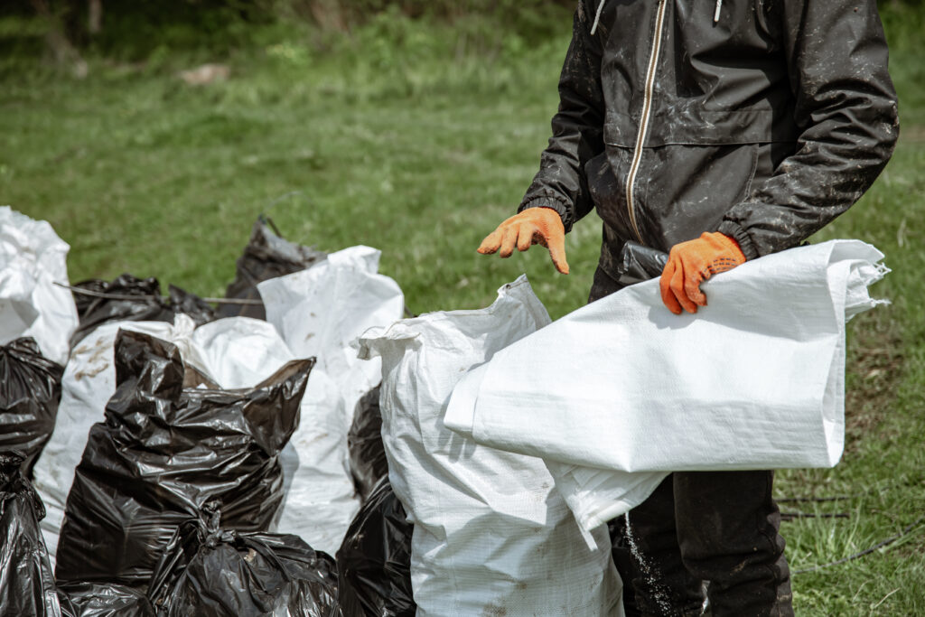 Close-up of garbage bags in the forest on the grass.